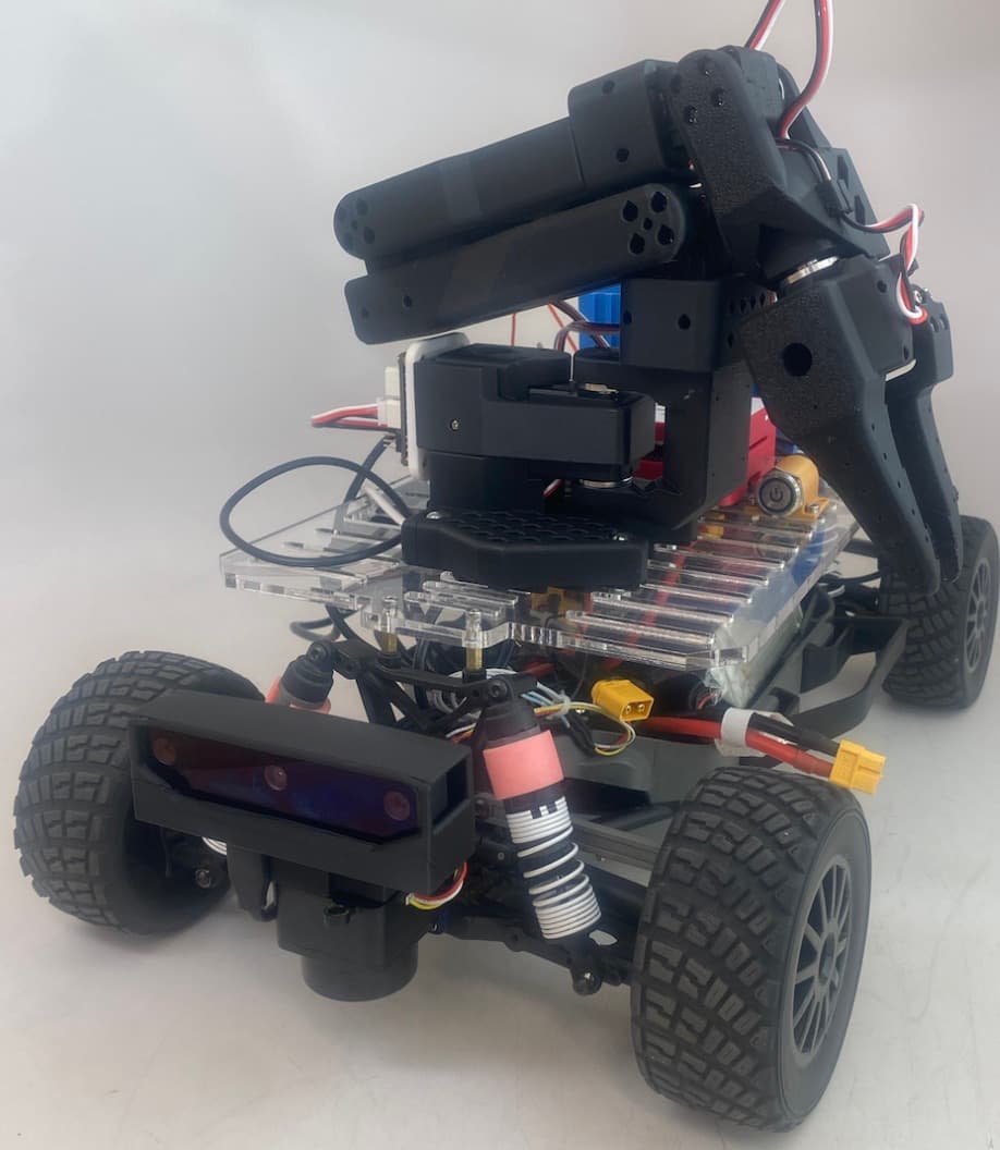 Finished MAE 148 autonomous trash collection robot with camera, arm, and electronics integrated on the vehicle
